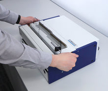 Load image into Gallery viewer, A person's hands are shown operating a FORMAX binding machine removing the punch die