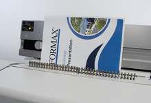 Load image into Gallery viewer, A Formax Business Presentation slide deck being printed or fed through a large white and gray binding machine with the cover page visible and a small control panel on the left.