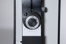 Load image into Gallery viewer, Close-up of a machine control dial with a black and silver circular knob and white scale markings, mounted on a gray metal housing.