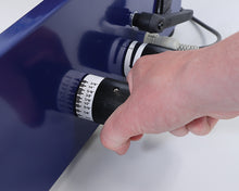 Load image into Gallery viewer, A close-up of a hand turning a black and white adjustment knob on a Wire200 binding machine